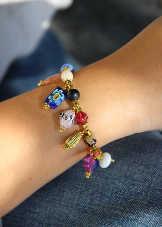 Bracciale Esmeralda di Laura Sciunnach – gioiello artigianale fatto a mano con perle colorate e ciondoli unici in vetro, ispirato allo stile creativo degli anni ’80. Bracciale elegante e versatile, perfetto per chi ama distinguersi con accessori originali.