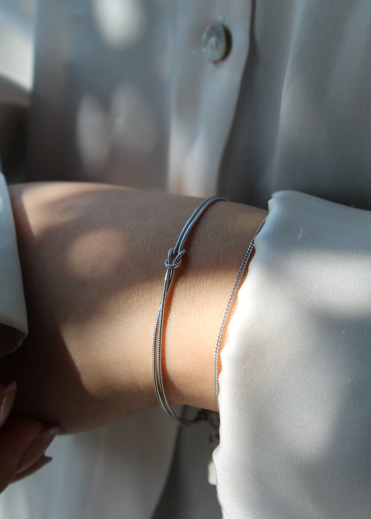 Bracciale con nodo a doppio filo in argento 925, dal design elegante e simbolico. Disponibile nella versione in argento naturale o con placcatura in oro, si adatta perfettamente a ogni stile. La chiusura regolabile garantisce una vestibilità comoda e personalizzabile. Ideale come regalo o per arricchire il proprio look con un tocco raffinato.