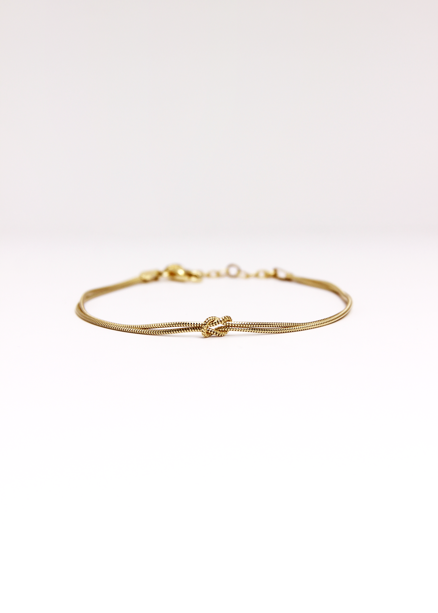 Bracciale in argento 925 con nodo, composto da due fili intrecciati. Disponibile anche in versione placcato oro. La lunghezza del bracciale è regolabile, per una vestibilità personalizzata.