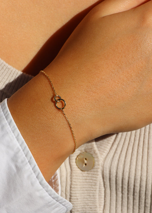 Bracciale in oro 9 carati Forever di Laura Sciunnach con due cerchi intrecciati, design minimal made in Italy.