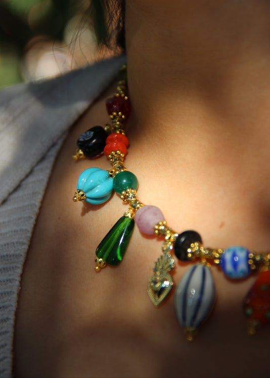 Collana Esmeralda di Laura Sciunnach – gioiello artigianale fatto a mano con ciondoli colorati e perle in vetro, ispirato allo stile audace degli anni ’80. Collana unica e irripetibile, ideale per look casual ed eleganti.