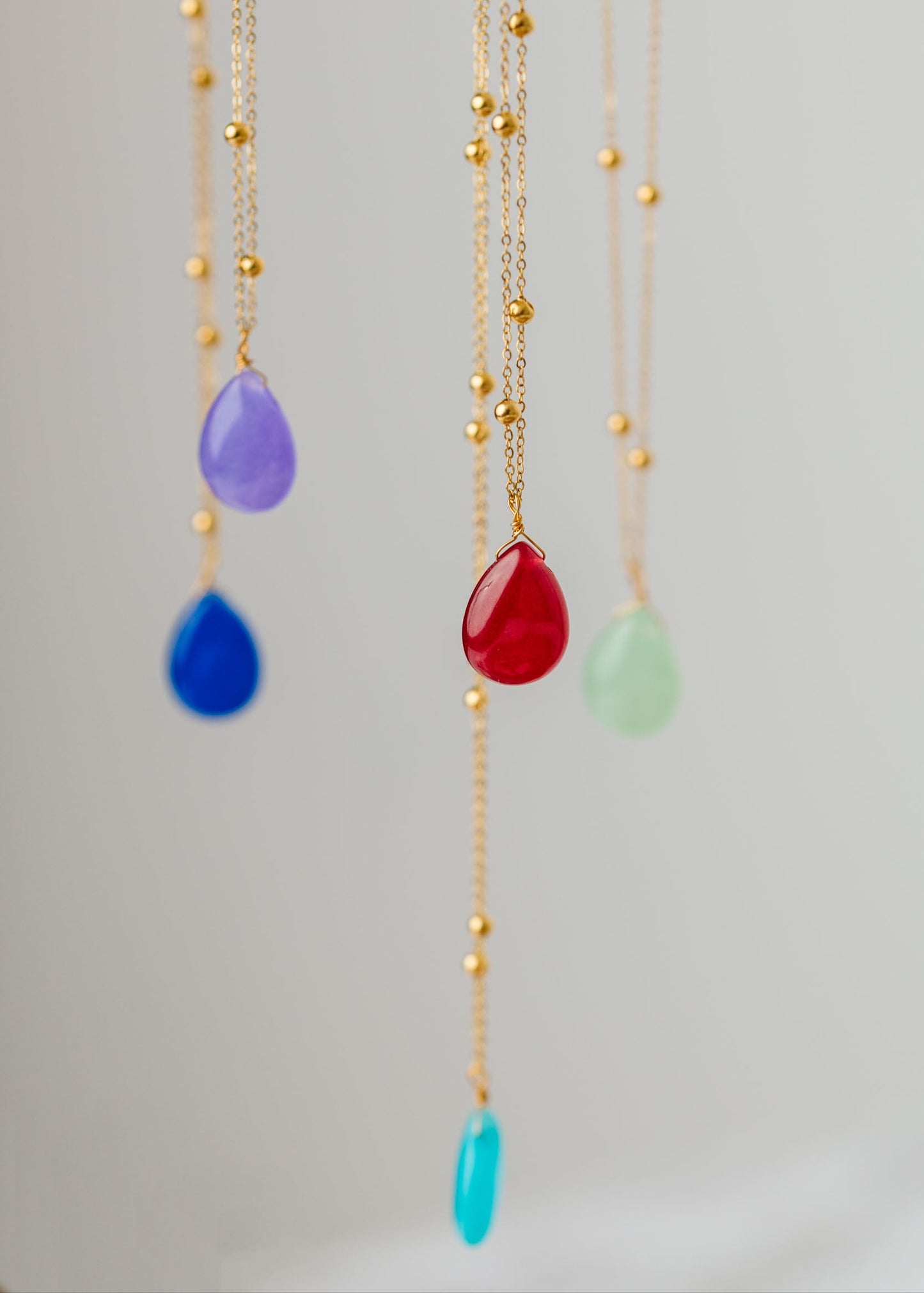 Collana artigianale Rugiada di Laura Sciunnach in acciaio inossidabile placcato oro, con pendente a goccia e pietre naturali colorate, elegante gioiello da donna di 70 cm perfetto per ogni occasione.