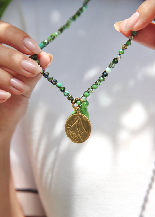 Collana lunga artigianale Laura Sciunnach con cristalli sfaccettati, ciondolo a forma di moneta e nappina in tessuto – gioiello fatto a mano made in Italy.