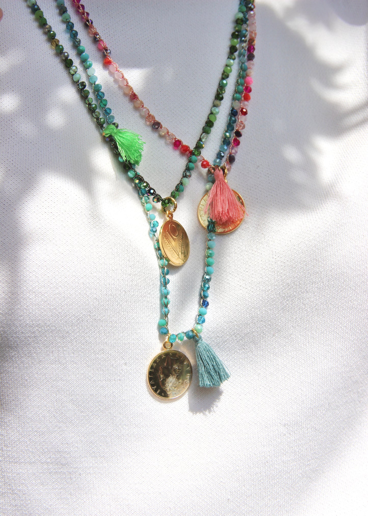 Collana lunga artigianale Laura Sciunnach con cristalli sfaccettati, ciondolo a forma di moneta e nappina in tessuto – gioiello fatto a mano made in Italy.