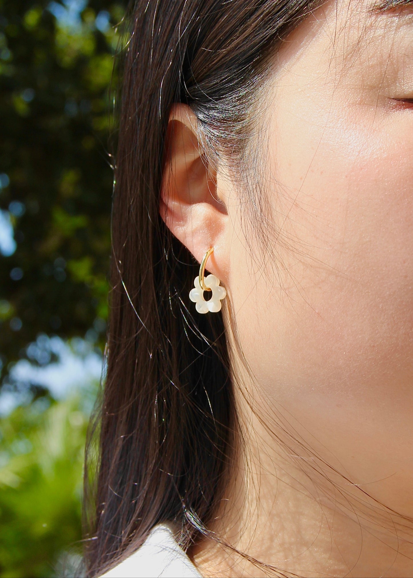 Orecchini ad anello in acciaio dorato con chiusura a scattino e ciondolo a forma di fiore in resina – colori rosa, azzurro, crema, arancione, fantasia blu-arancione e fantasia blu-verde – stile giocoso, primaverile ed estivo – bijoux leggeri e colorati.
