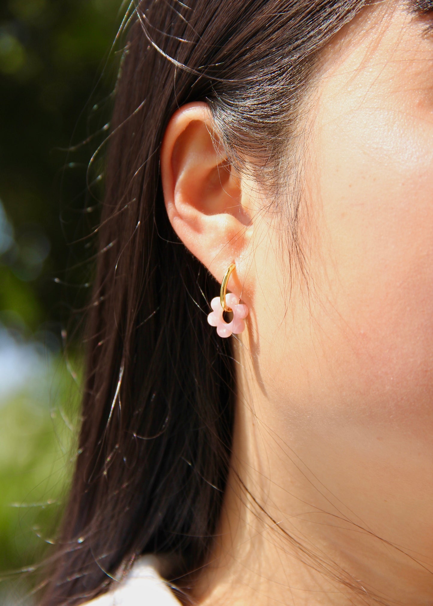 Orecchini ad anello in acciaio dorato con chiusura a scattino e ciondolo a forma di fiore in resina – colori rosa, azzurro, crema, arancione, fantasia blu-arancione e fantasia blu-verde – stile giocoso, primaverile ed estivo – bijoux leggeri e colorati.