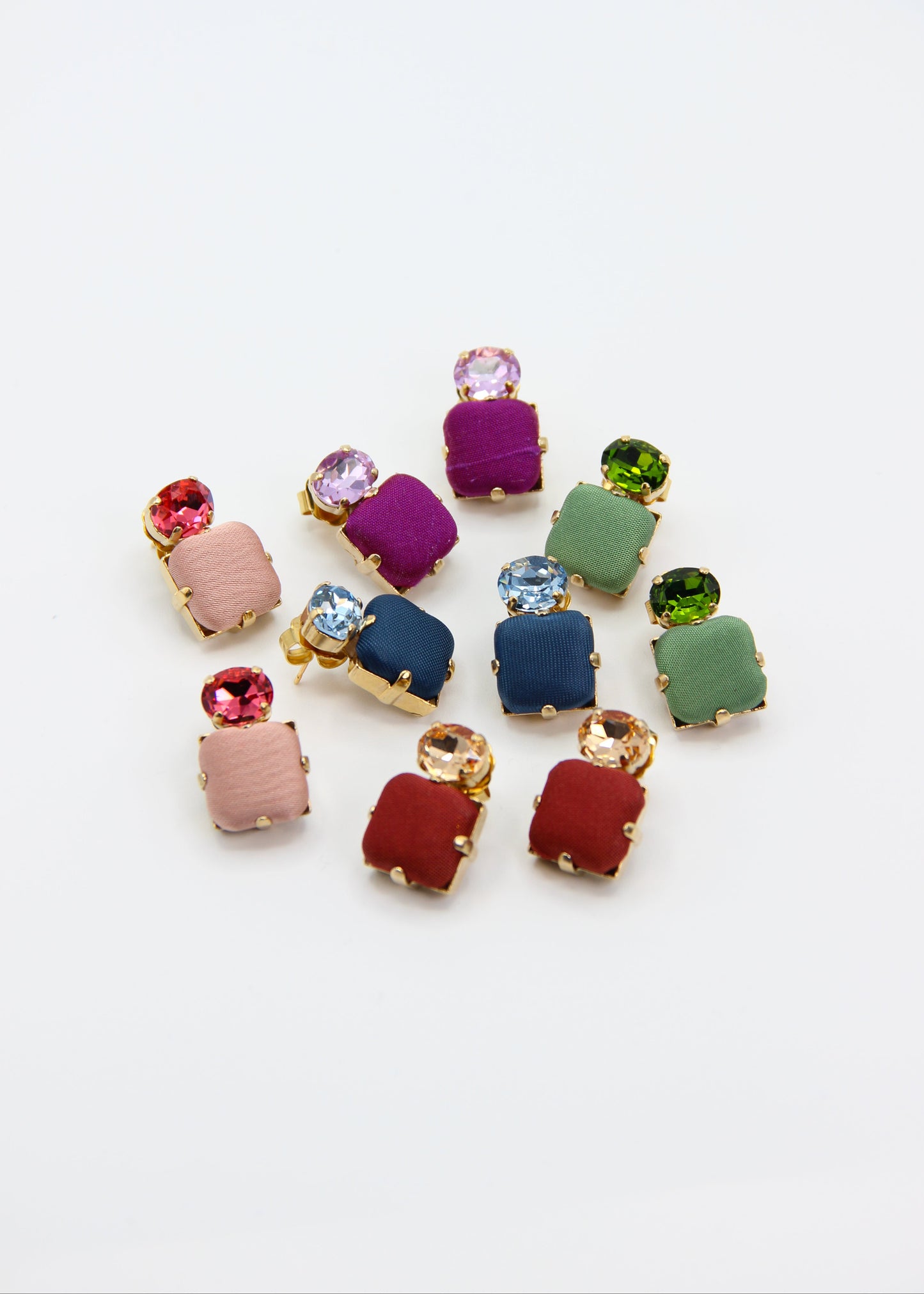 Orecchini verde salvia eleganti fatti a mano da Laura Sciunnach Bijoux, modello Metropolitan Siviglia con bottone quadrato in stoffa verde salvia e cristallo ovale verde tono su tono, design geometrico leggero e raffinato.