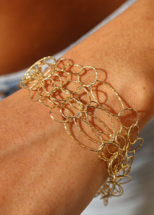 Bracciale Intreccio di Laura Sciunnach, artigianale, cinque fili a maglie irregolari in argento 925, oro giallo o oro rosa, con piccola monetina pendente, elegante e contemporaneo.