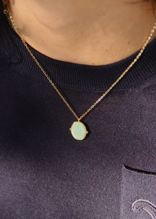 Collana in acciaio placcato oro con ciondolo ovale in pietra dura naturale e catena a maglia rettangolare fine. Disponibile in diversi colori, dal design elegante e senza tempo. Ogni pietra presenta variazioni naturali di colore e venature