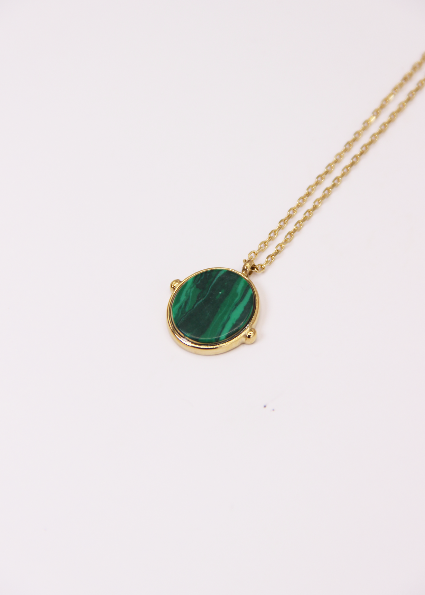 Collana in acciaio placcato oro con ciondolo ovale in pietra dura naturale e catena a maglia rettangolare fine. Disponibile in diversi colori, dal design elegante e senza tempo. Ogni pietra presenta variazioni naturali di colore e venature