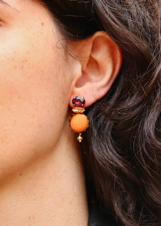 Orecchino artigianale Metropolitan realizzato da laura sciunnach bijoux modello Venezia con bottone in stoffa arancione, cristalli tagliati e perlina pendente – gioiello fatto a mano, leggero e personalizzabile, ispirato alla città di Venezia.