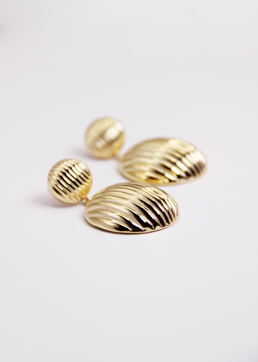 Orecchino pendente chunky con chiusura a perno, composto da due bottoni con texture rigata. Realizzato in argento 925, disponibile anche placcato oro per un tocco di eleganza in più. La lunghezza totale dell'orecchino è di 3,8 cm, con un diametro del bottone inferiore di 2,3 cm, ideale per un look sofisticato e moderno.