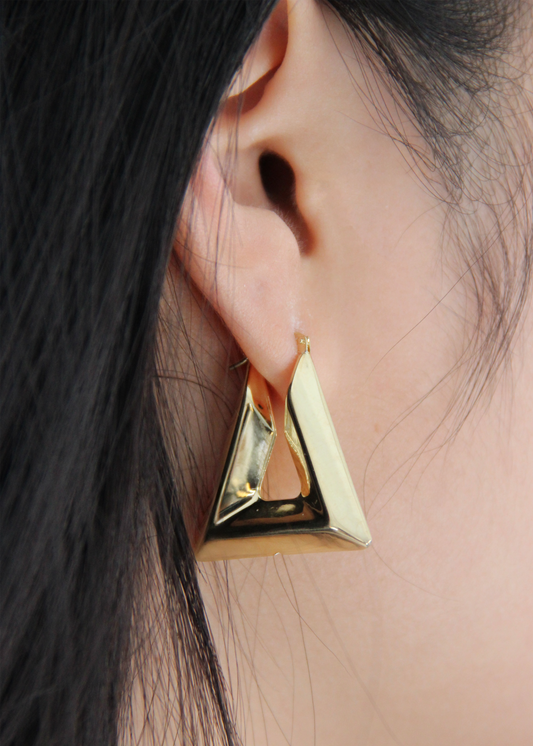Orecchino chunky a forma di triangolo in Argento 925 placcato oro giallo, con superficie liscia e lucida. Design audace e geometrico, con chiusura a baionetta per una vestibilità sicura.  
Dimensioni: 3,2 cm di lunghezza, 3 cm di larghezza alla base.