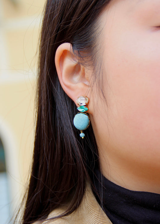 Orecchino artigianale Metropolitan realizzato da laura sciunnach bijoux modello Venezia con bottone in stoffa azzurra, cristalli tagliati e perlina pendente – gioiello fatto a mano, leggero e personalizzabile, ispirato alla città di Venezia.