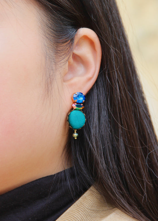 Orecchino artigianale Metropolitan realizzato da laura sciunnach bijoux modello Venezia con bottone in stoffa blu pavone, cristalli tagliati e perlina pendente – gioiello fatto a mano, leggero e personalizzabile, ispirato alla città di Venezia.