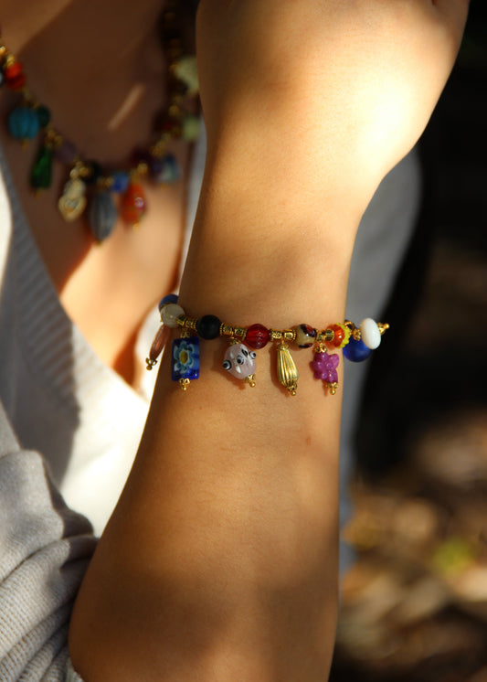 Bracciale Esmeralda di Laura Sciunnach – gioiello artigianale fatto a mano con perle colorate e ciondoli unici in vetro, ispirato allo stile creativo degli anni ’80. Bracciale elegante e versatile, perfetto per chi ama distinguersi con accessori originali.