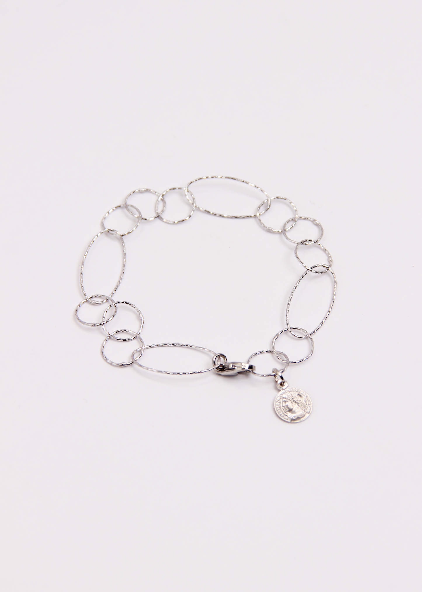 Bracciale Intreccio mono filo di Laura Sciunnach, artigianale, un unico filo a maglie irregolari in argento 925, oro giallo o oro rosa, con piccola monetina pendente, minimalista ed elegante, gioiello contemporaneo.