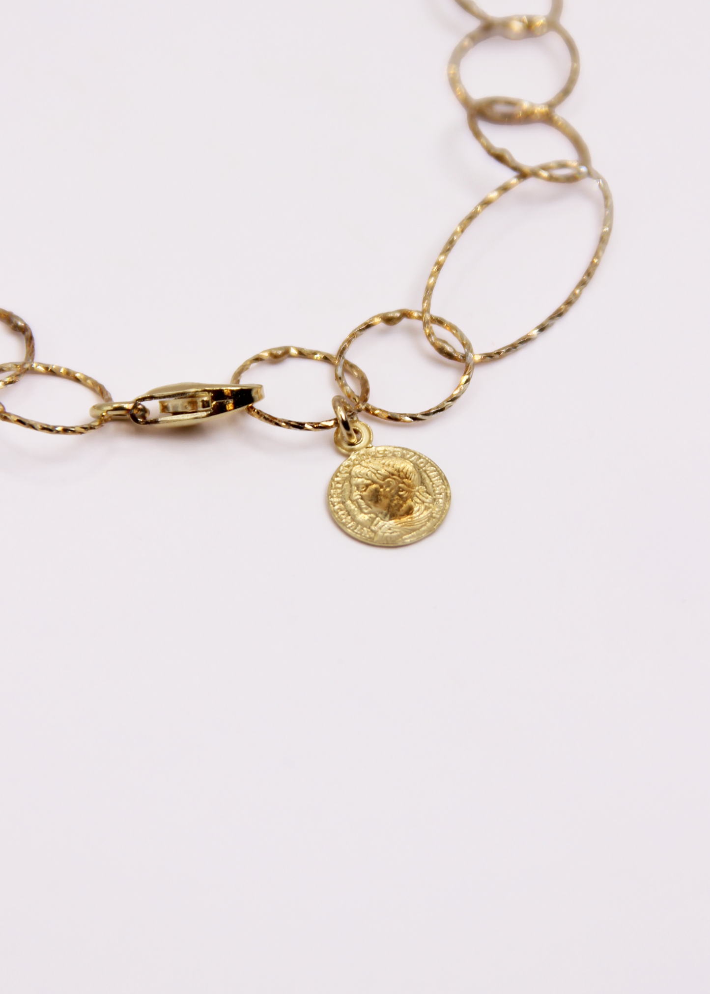 Bracciale Intreccio mono filo di Laura Sciunnach, artigianale, un unico filo a maglie irregolari in argento 925, oro giallo o oro rosa, con piccola monetina pendente, minimalista ed elegante, gioiello contemporaneo.