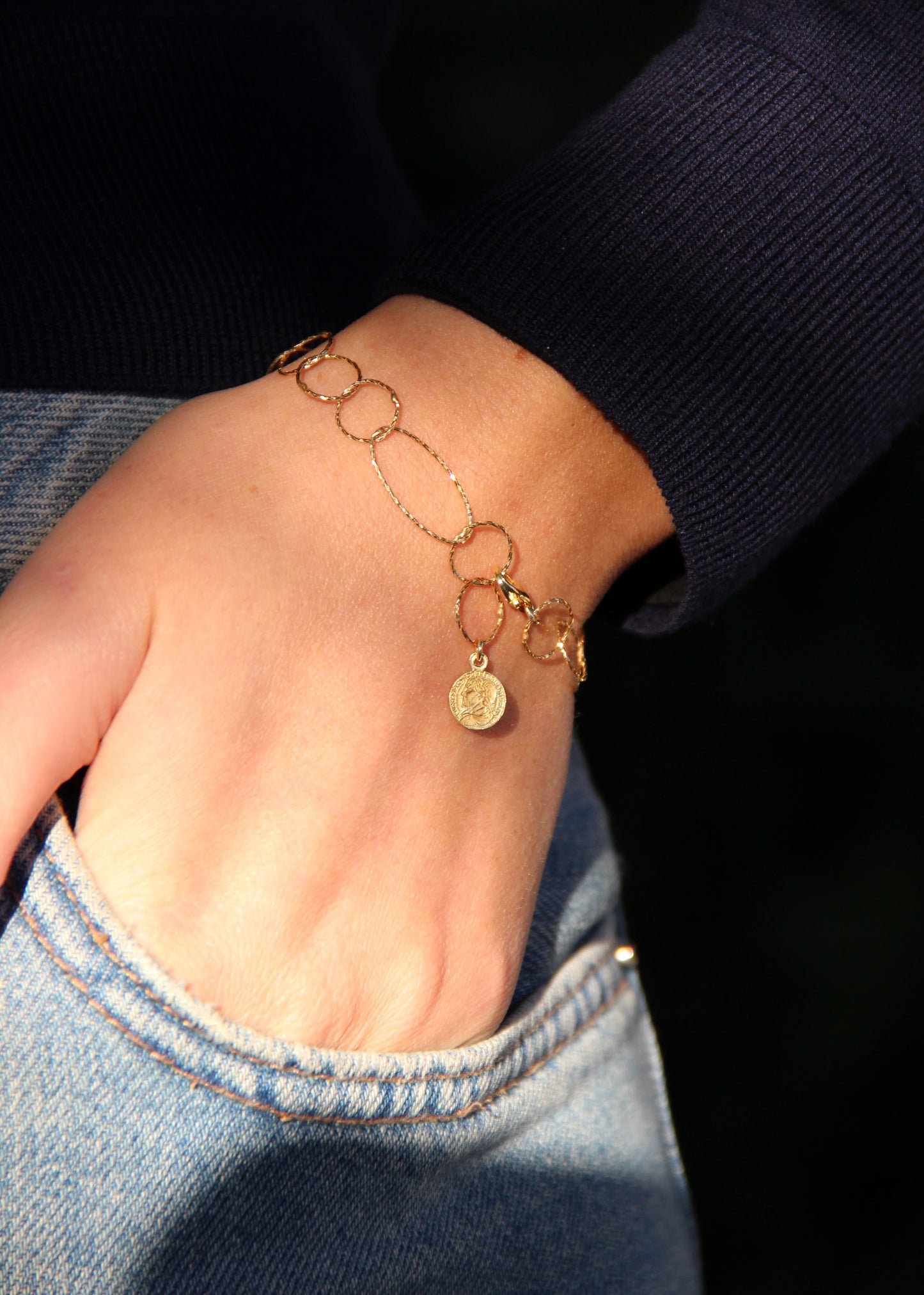 Bracciale Intreccio mono filo di Laura Sciunnach, artigianale, un unico filo a maglie irregolari in argento 925, oro giallo o oro rosa, con piccola monetina pendente, minimalista ed elegante, gioiello contemporaneo.