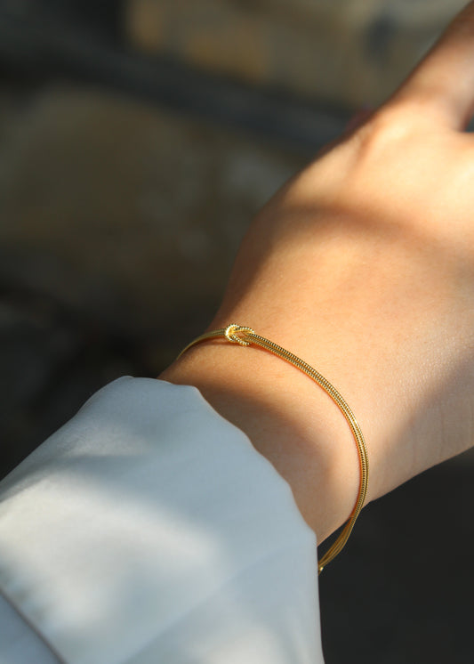 Bracciale con nodo a doppio filo in argento 925, dal design elegante e simbolico. Disponibile nella versione in argento naturale o con placcatura in oro, si adatta perfettamente a ogni stile. La chiusura regolabile garantisce una vestibilità comoda e personalizzabile. Ideale come regalo o per arricchire il proprio look con un tocco raffinato.