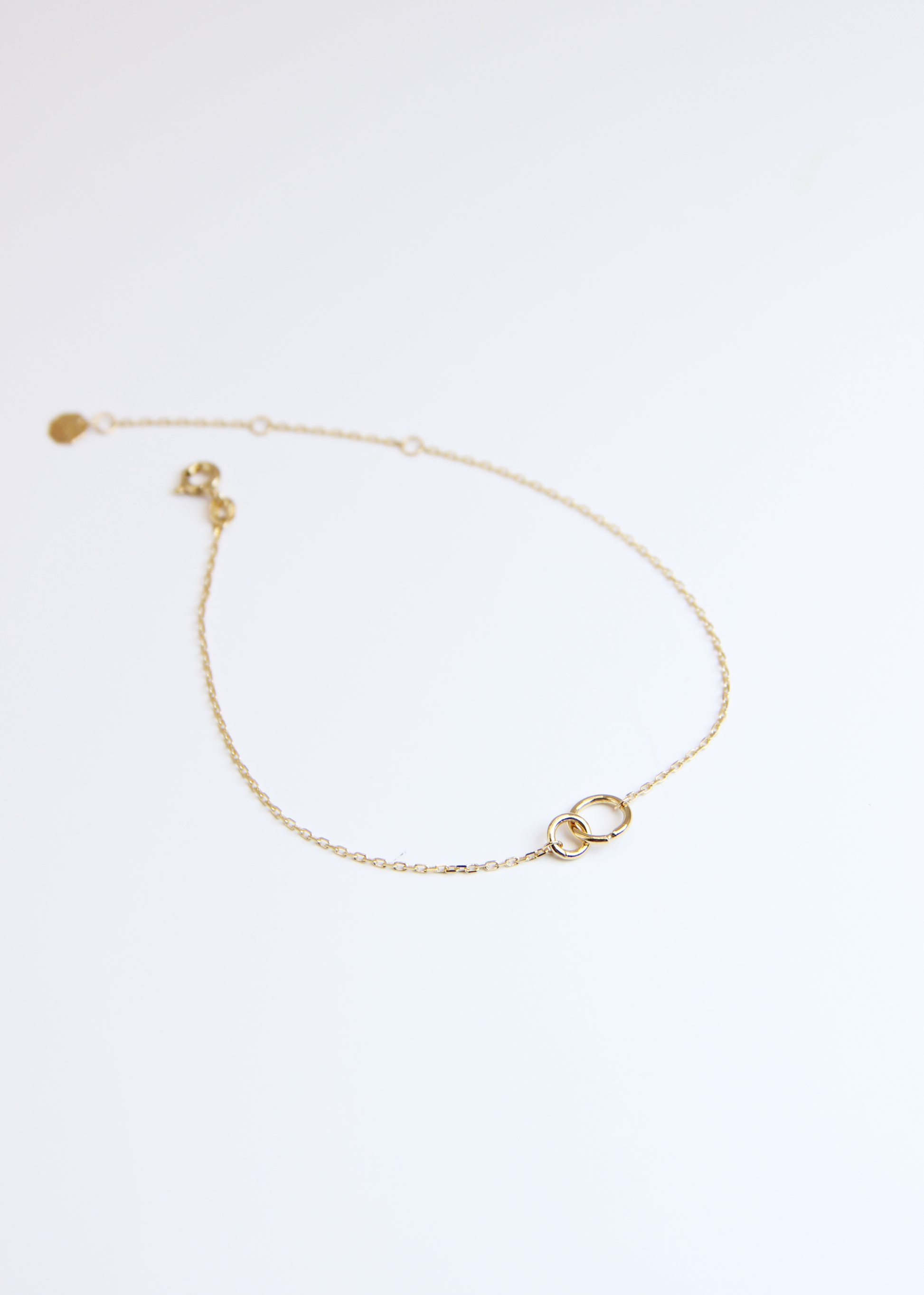 Bracciale in oro 9 carati Forever di Laura Sciunnach con due cerchi intrecciati, design minimal made in Italy.