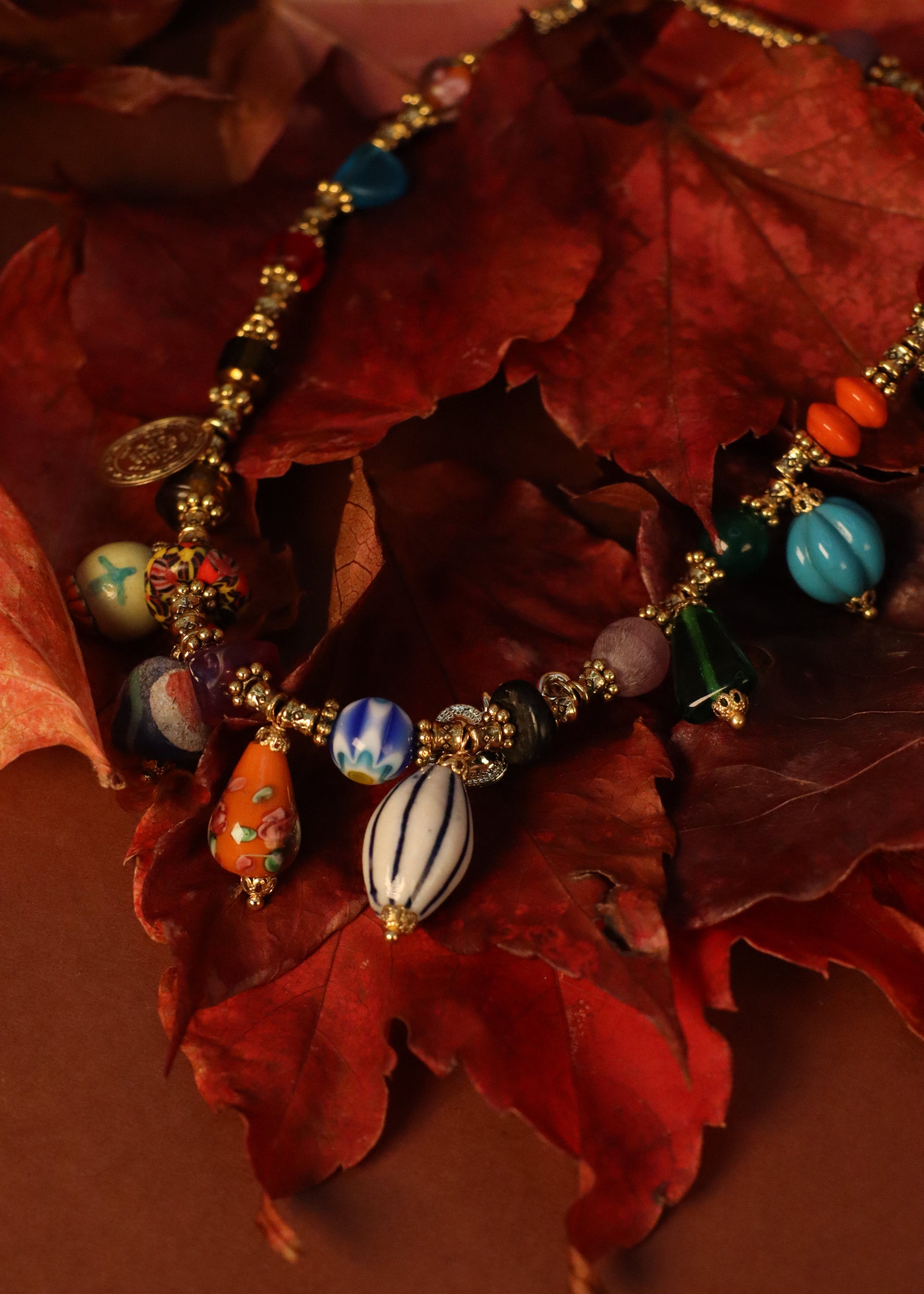 Collana Esmeralda di Laura Sciunnach – gioiello artigianale fatto a mano con ciondoli colorati e perle in vetro, ispirato allo stile audace degli anni ’80. Collana unica e irripetibile, ideale per look casual ed eleganti.