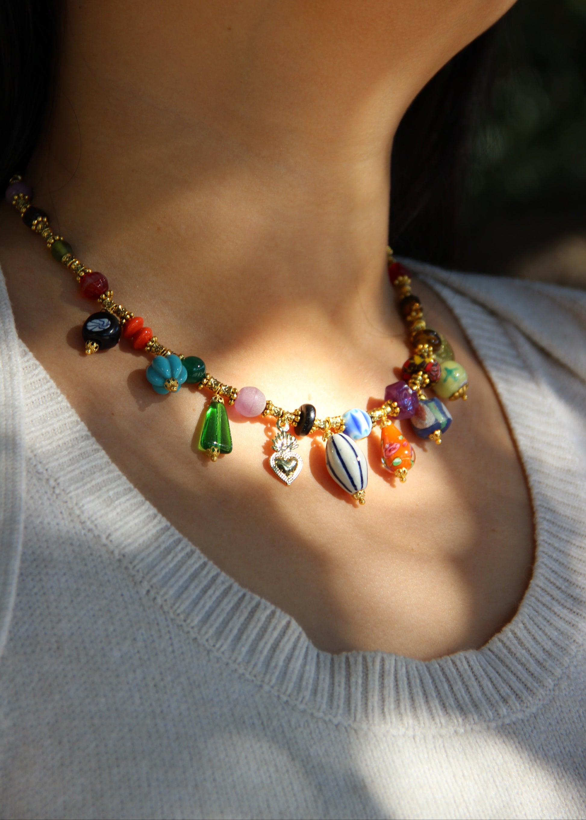 Collana Esmeralda di Laura Sciunnach – gioiello artigianale fatto a mano con ciondoli colorati e perle in vetro, ispirato allo stile audace degli anni ’80. Collana unica e irripetibile, ideale per look casual ed eleganti.