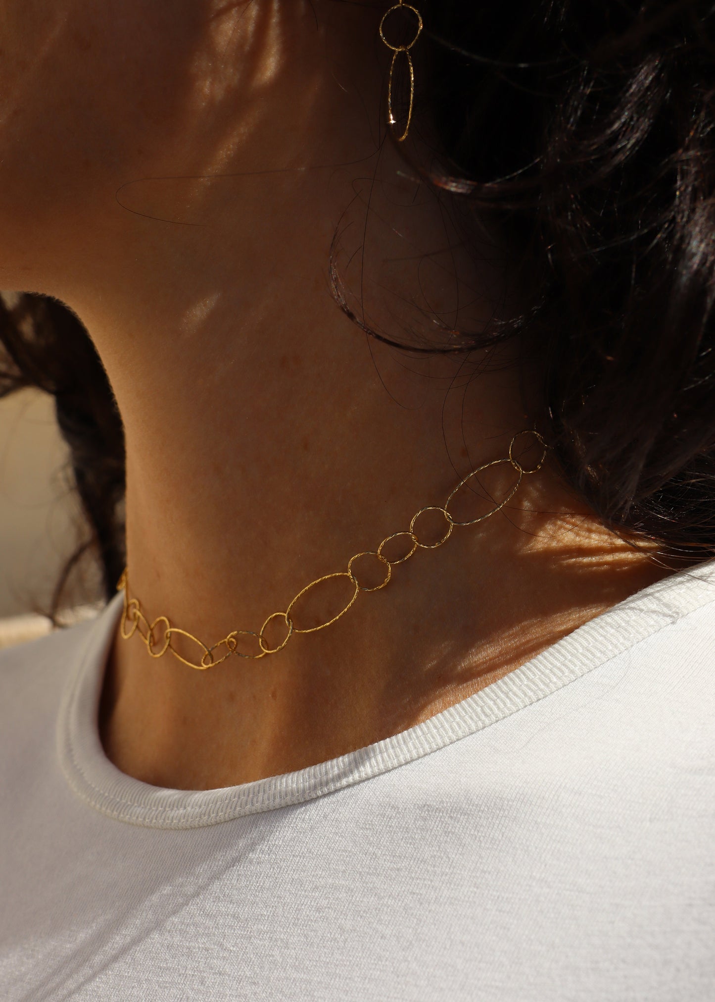 Collana Intreccio Laura Sciunnach in argento placcato oro, choker a maglie irregolari indossato al collo di una donna, gioiello artigianale italiano con design elegante.