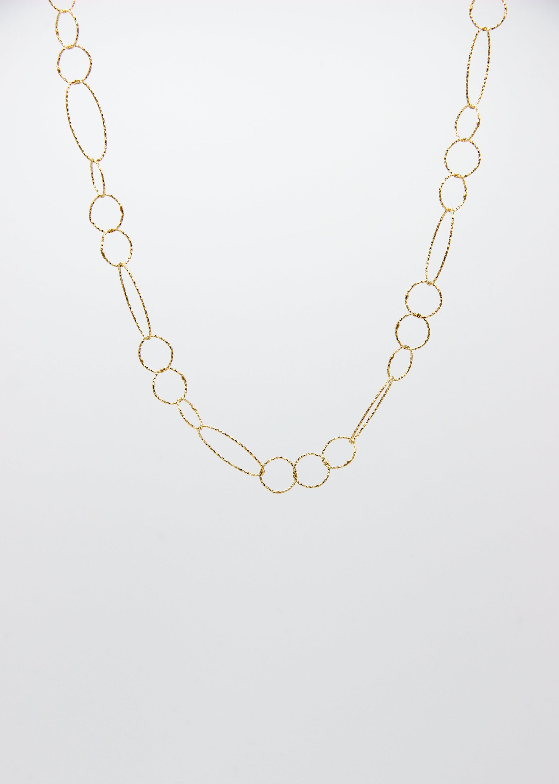 Collana Intreccio Laura Sciunnach lunga in argento placcato oro, maglie irregolari, collana artigianale italiana dal design elegante.
