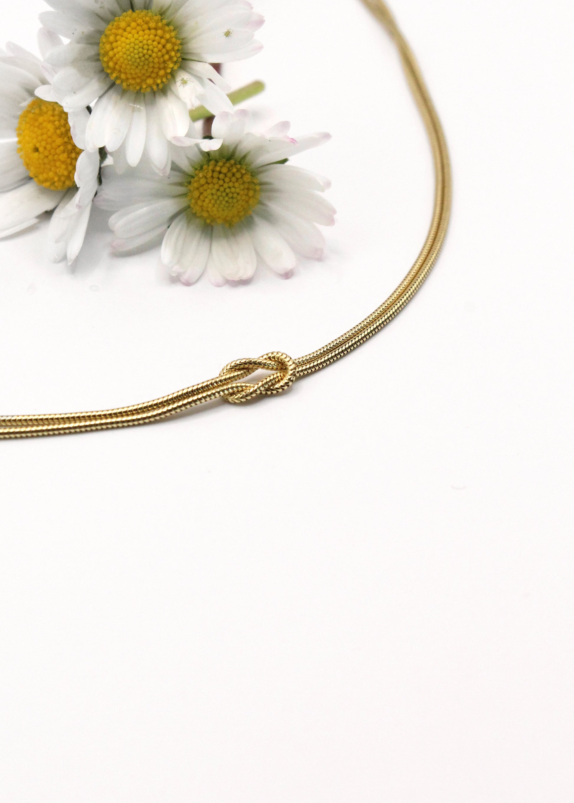 Collana in argento 925 con nodo, composta da due fili intrecciati. Disponibile anche in versione placcata oro. La lunghezza della collana è regolabile, per una vestibilità personalizzata