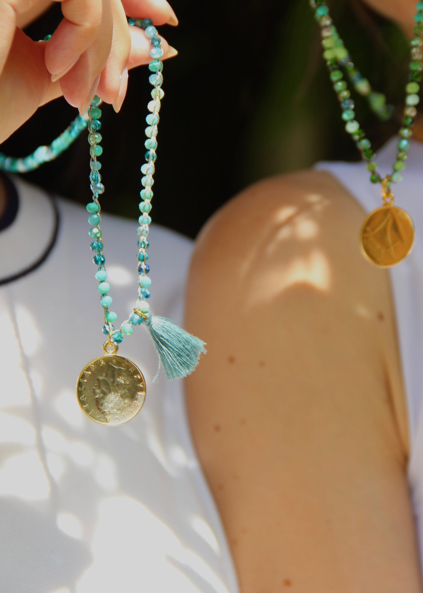 Collana lunga artigianale Laura Sciunnach con cristalli sfaccettati, ciondolo a forma di moneta e nappina in tessuto – gioiello fatto a mano made in Italy.