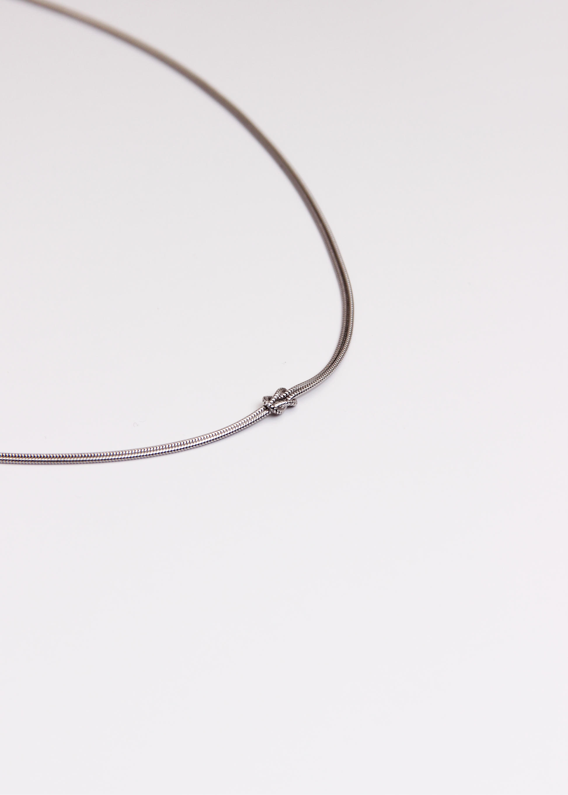 Collana in argento 925 con nodo, composta da due fili intrecciati. Disponibile anche in versione placcata oro. La lunghezza della collana è regolabile, per una vestibilità personalizzata
