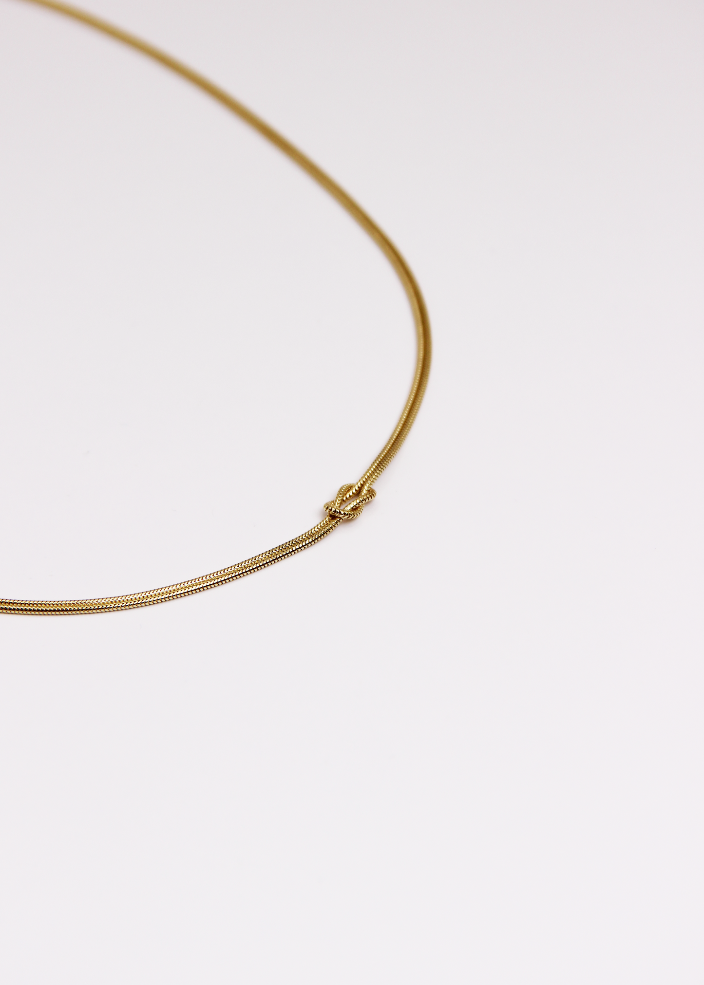 Collana in argento 925 con nodo, composta da due fili intrecciati. Disponibile anche in versione placcata oro. La lunghezza della collana è regolabile, per una vestibilità personalizzata