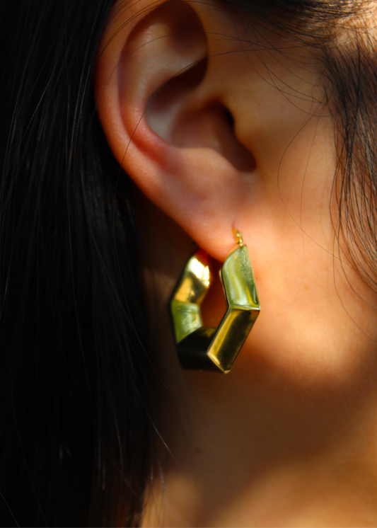 Orecchino chunky a forma esagonale in argento 925 placcato oro giallo, dal design audace e geometrico. Presenta una chiusura a baionetta per una vestibilità sicura. Diametro di 3 cm, ideale per un look elegante e moderno.