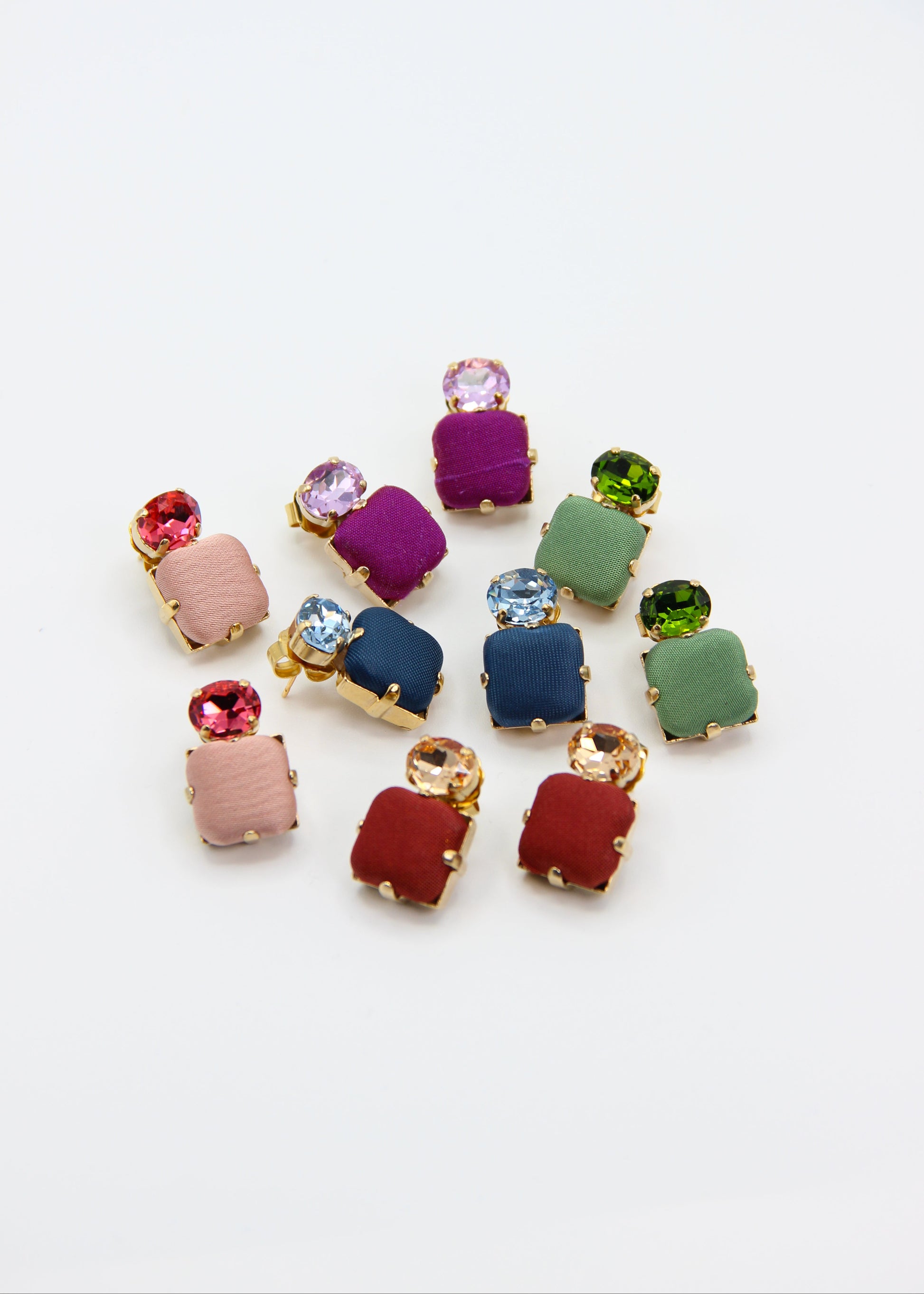 Orecchini viola eleganti fatti a mano da Laura Sciunnach Bijoux, modello Metropolitan Siviglia con bottone quadrato in stoffa viola e cristallo ovale lilla, design geometrico leggero e raffinato.