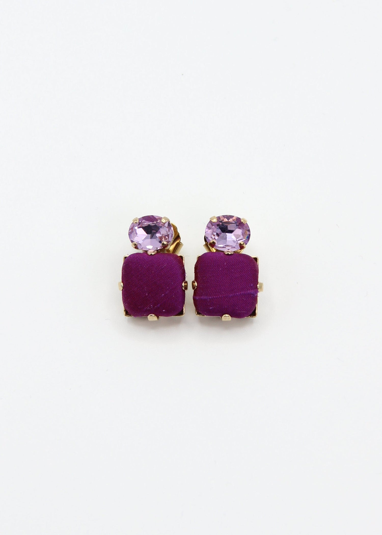Orecchini viola eleganti fatti a mano da Laura Sciunnach Bijoux, modello Metropolitan Siviglia con bottone quadrato in stoffa viola e cristallo ovale lilla, design geometrico leggero e raffinato.