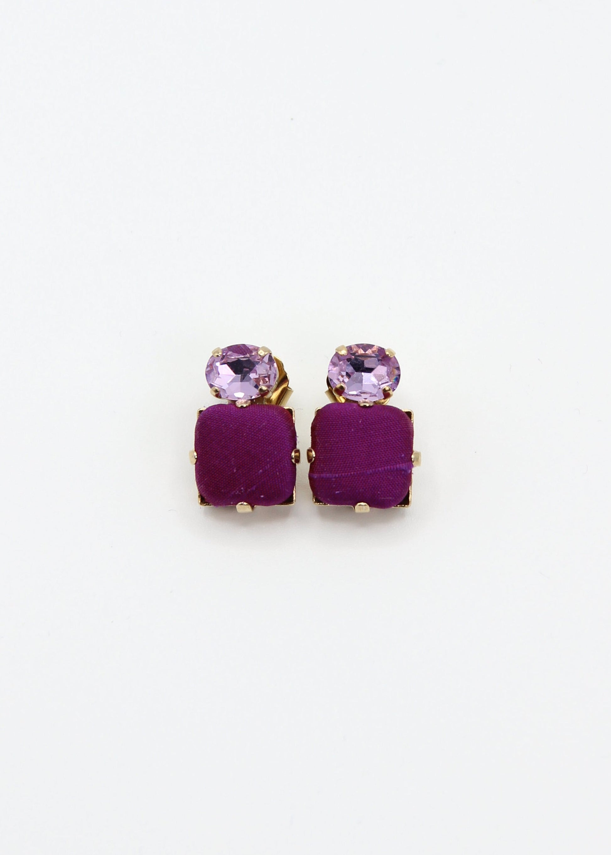 Orecchini viola eleganti fatti a mano da Laura Sciunnach Bijoux, modello Metropolitan Siviglia con bottone quadrato in stoffa viola e cristallo ovale lilla, design geometrico leggero e raffinato.