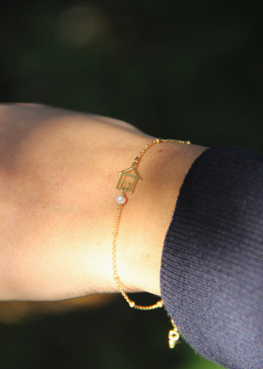 Bracciale artigianale fatto a mano da Laura Sciunnach Bijoux in argento 925, con catena rosario e ciondolo a forma di casetta con pietra dura naturale. Disponibile in perla di lago, radice di rubino, agata nera e agata verde, e nelle varianti argento, argento placcato oro e oro rosa. Chiusura a moschettone, lunghezza regolabile