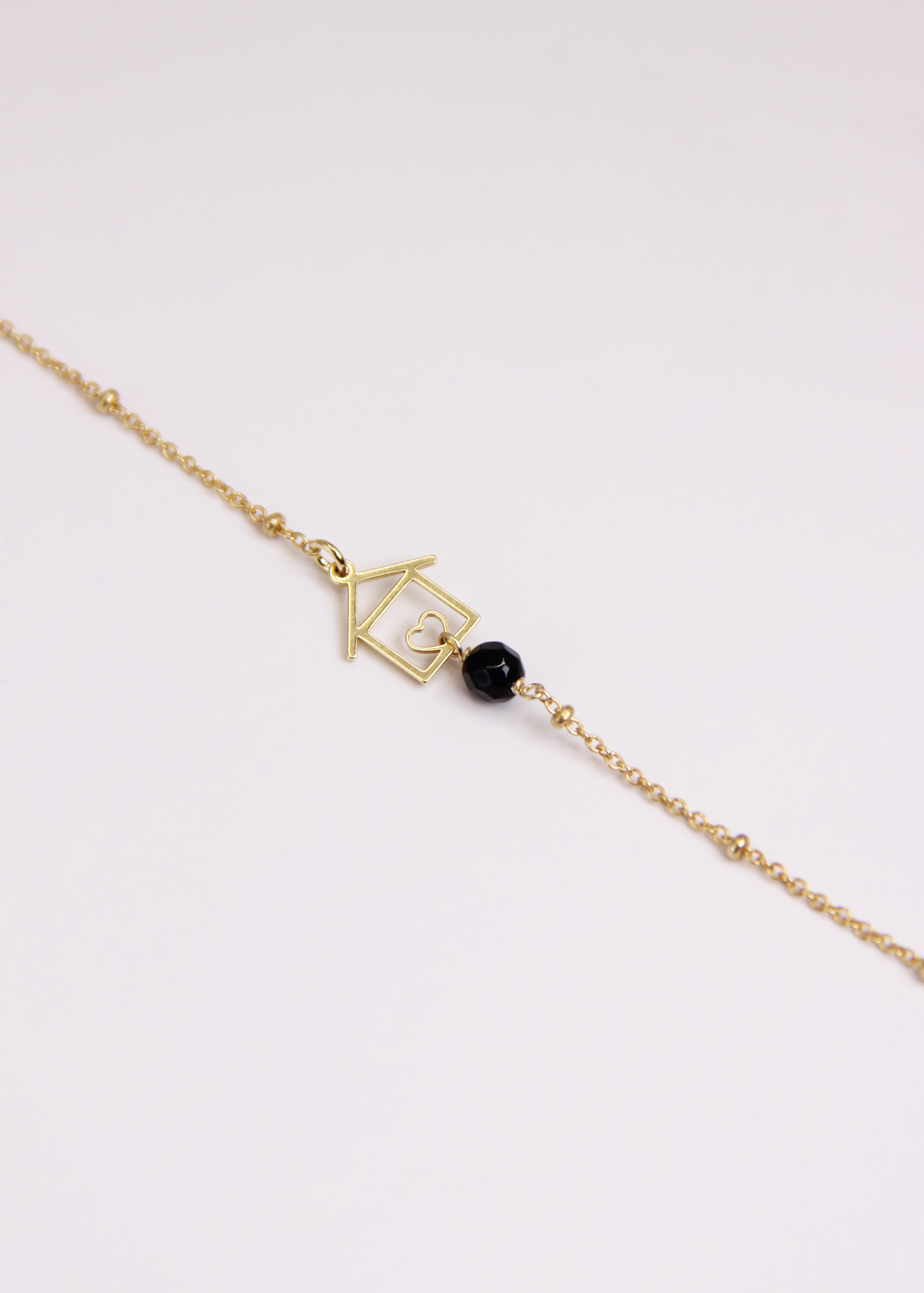 Bracciale artigianale fatto a mano da Laura Sciunnach Bijoux in argento 925, con catena rosario e ciondolo a forma di casetta con pietra dura naturale. Disponibile in perla di lago, radice di rubino, agata nera e agata verde, e nelle varianti argento, argento placcato oro e oro rosa. Chiusura a moschettone, lunghezza regolabile