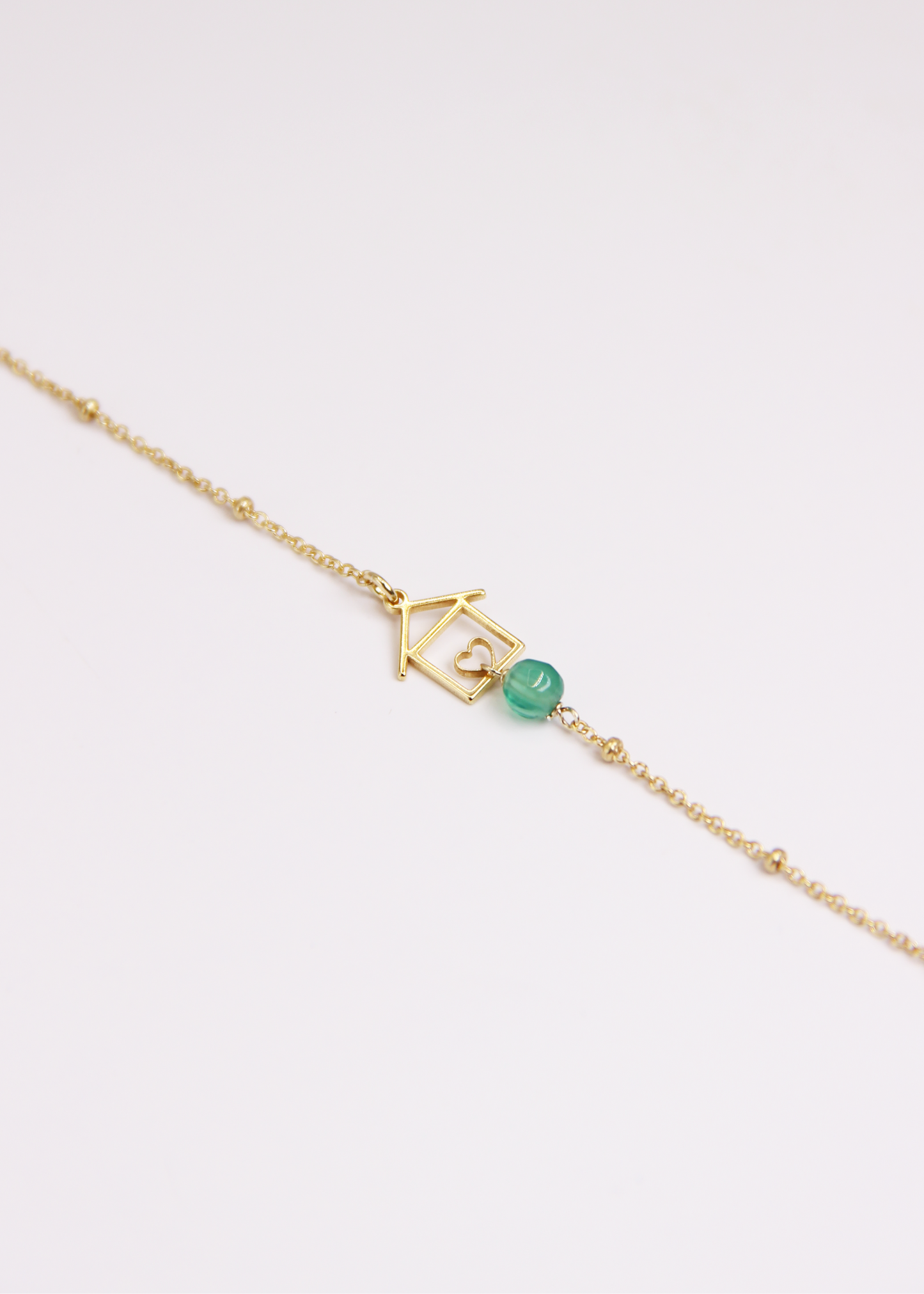 Bracciale artigianale fatto a mano da Laura Sciunnach Bijoux in argento 925, con catena rosario e ciondolo a forma di casetta con pietra dura naturale. Disponibile in perla di lago, radice di rubino, agata nera e agata verde, e nelle varianti argento, argento placcato oro e oro rosa. Chiusura a moschettone, lunghezza regolabile