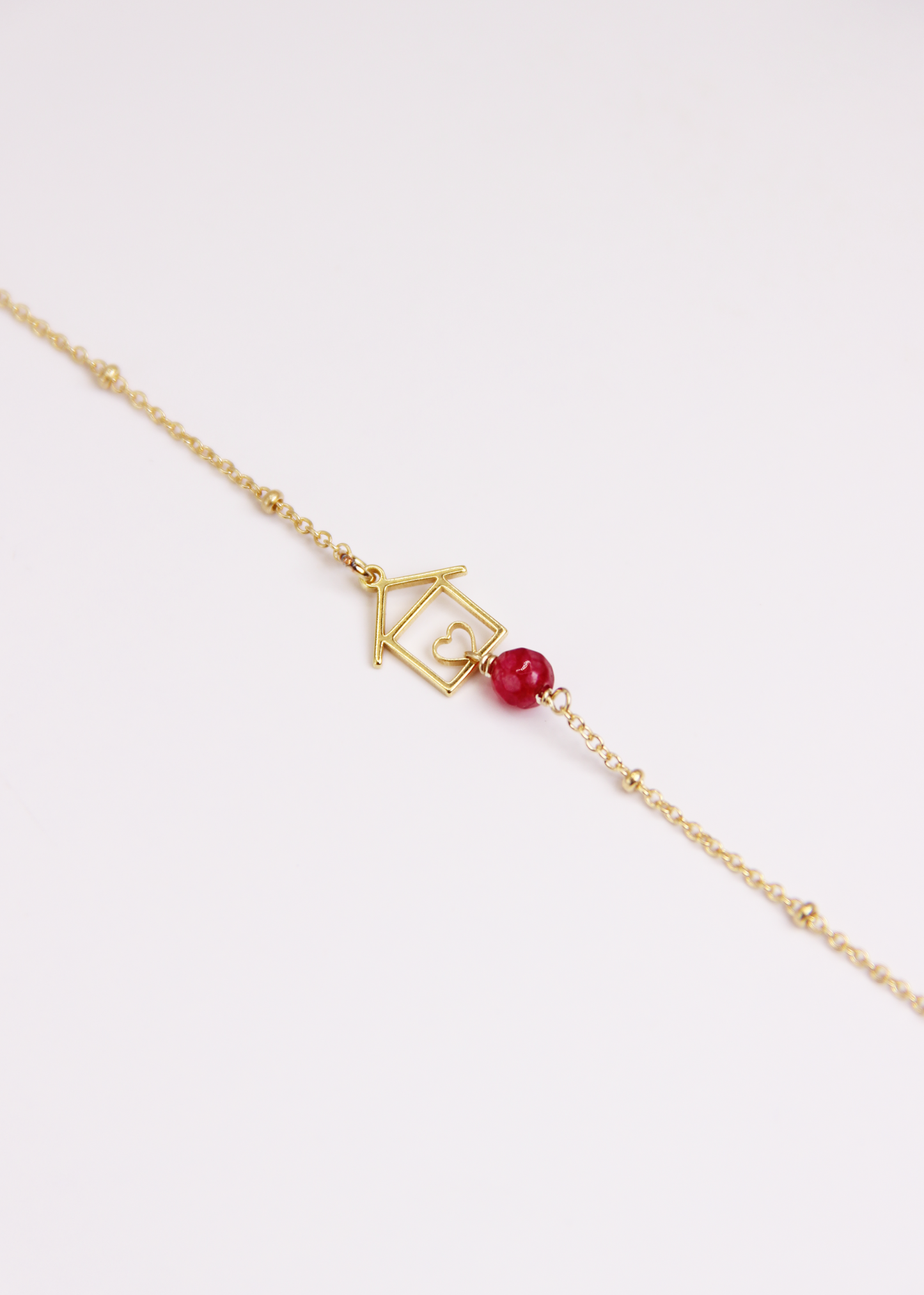 Bracciale artigianale fatto a mano da Laura Sciunnach Bijoux in argento 925, con catena rosario e ciondolo a forma di casetta con pietra dura naturale. Disponibile in perla di lago, radice di rubino, agata nera e agata verde, e nelle varianti argento, argento placcato oro e oro rosa. Chiusura a moschettone, lunghezza regolabile