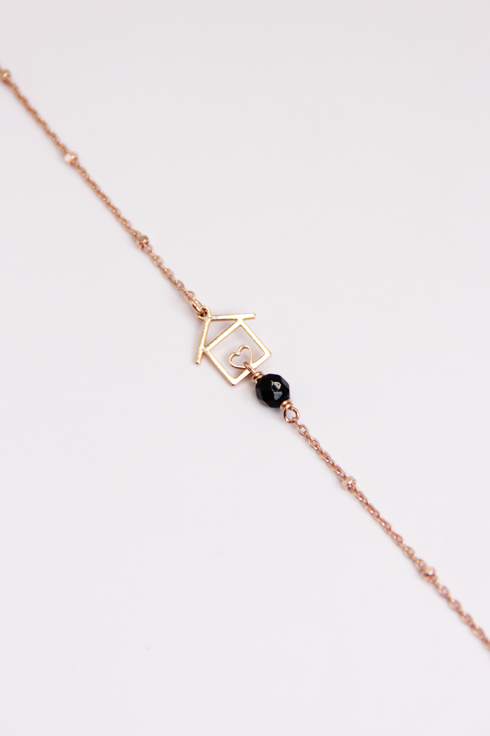 Bracciale artigianale fatto a mano da Laura Sciunnach Bijoux in argento 925, con catena rosario e ciondolo a forma di casetta con pietra dura naturale. Disponibile in perla di lago, radice di rubino, agata nera e agata verde, e nelle varianti argento, argento placcato oro e oro rosa. Chiusura a moschettone, lunghezza regolabile