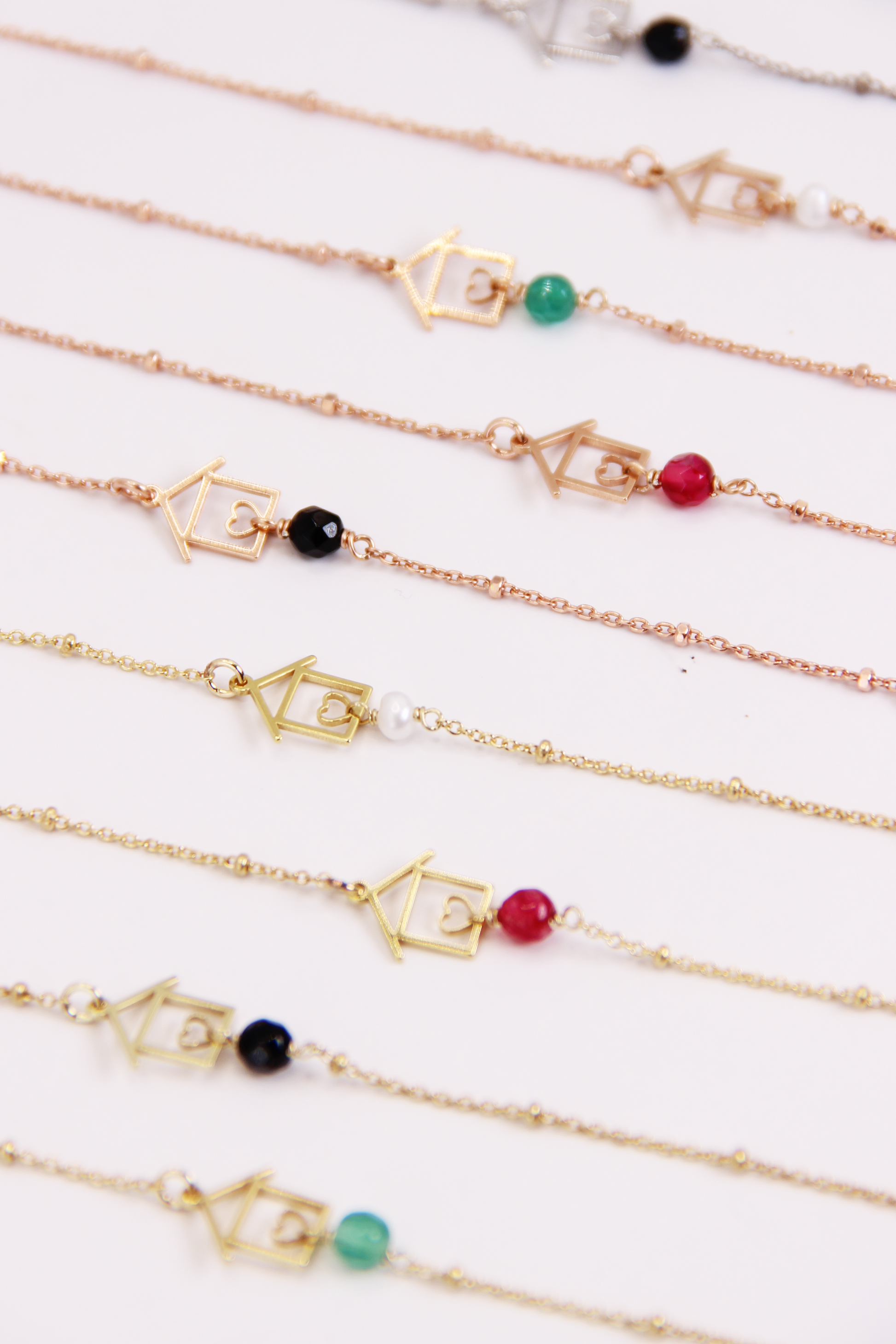 Bracciale artigianale fatto a mano da Laura Sciunnach Bijoux in argento 925, con catena rosario e ciondolo a forma di casetta con pietra dura naturale. Disponibile in perla di lago, radice di rubino, agata nera e agata verde, e nelle varianti argento, argento placcato oro e oro rosa. Chiusura a moschettone, lunghezza regolabile