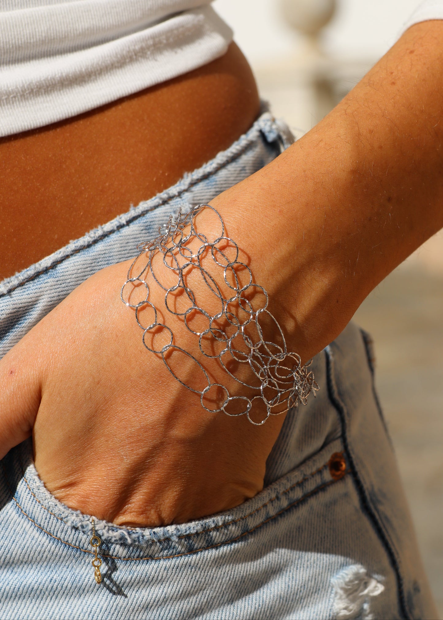 Bracciale Intreccio di Laura Sciunnach, artigianale, cinque fili a maglie irregolari in argento 925, oro giallo o oro rosa, con piccola monetina pendente, elegante e contemporaneo.