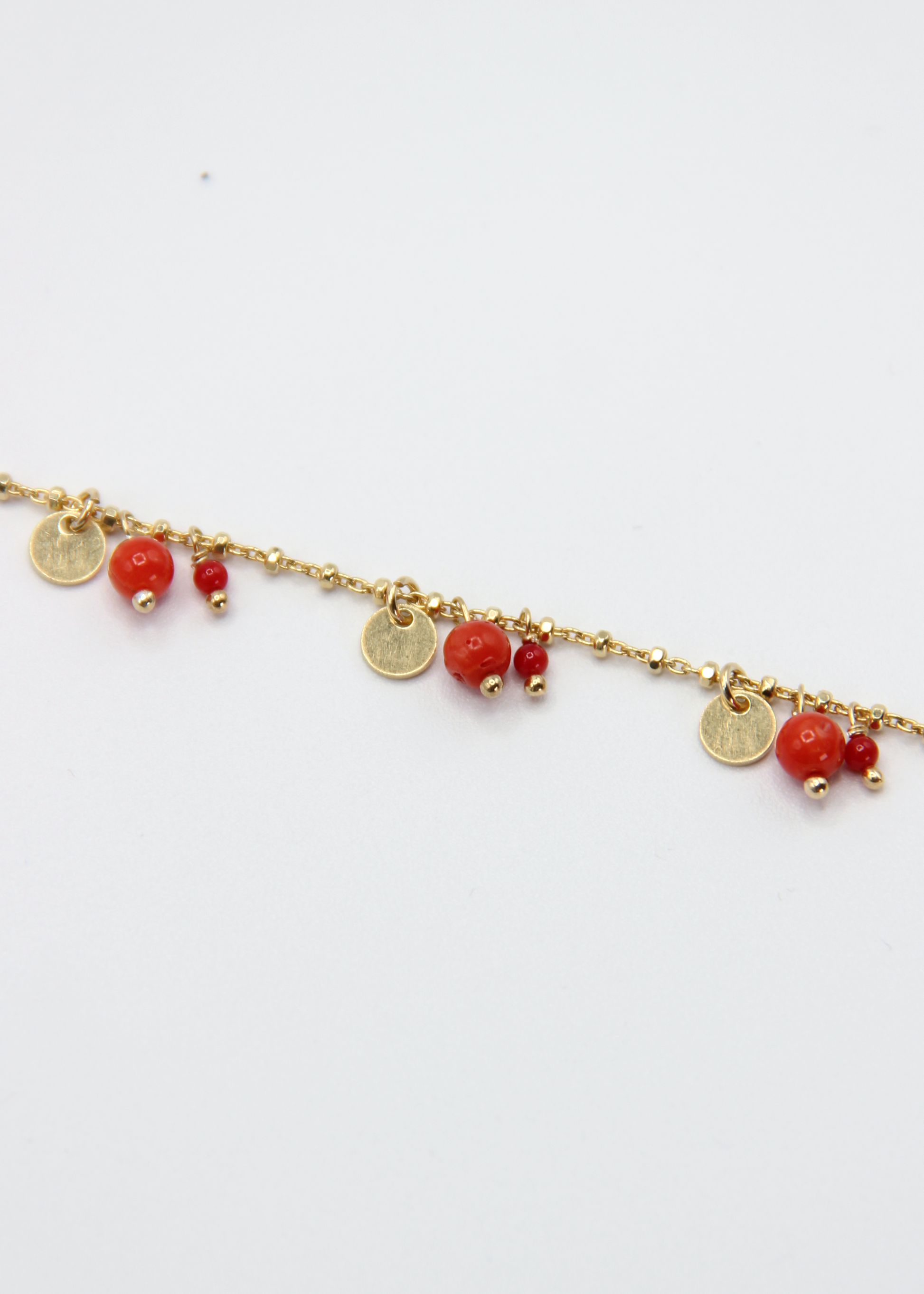 Dettaglio del corallo naturale e dei ciondoli rotondi del bracciale Little Princess Summer Edition Laura Sciunnach. Gioiello artigianale Made in Italy perfetto per l’estate.