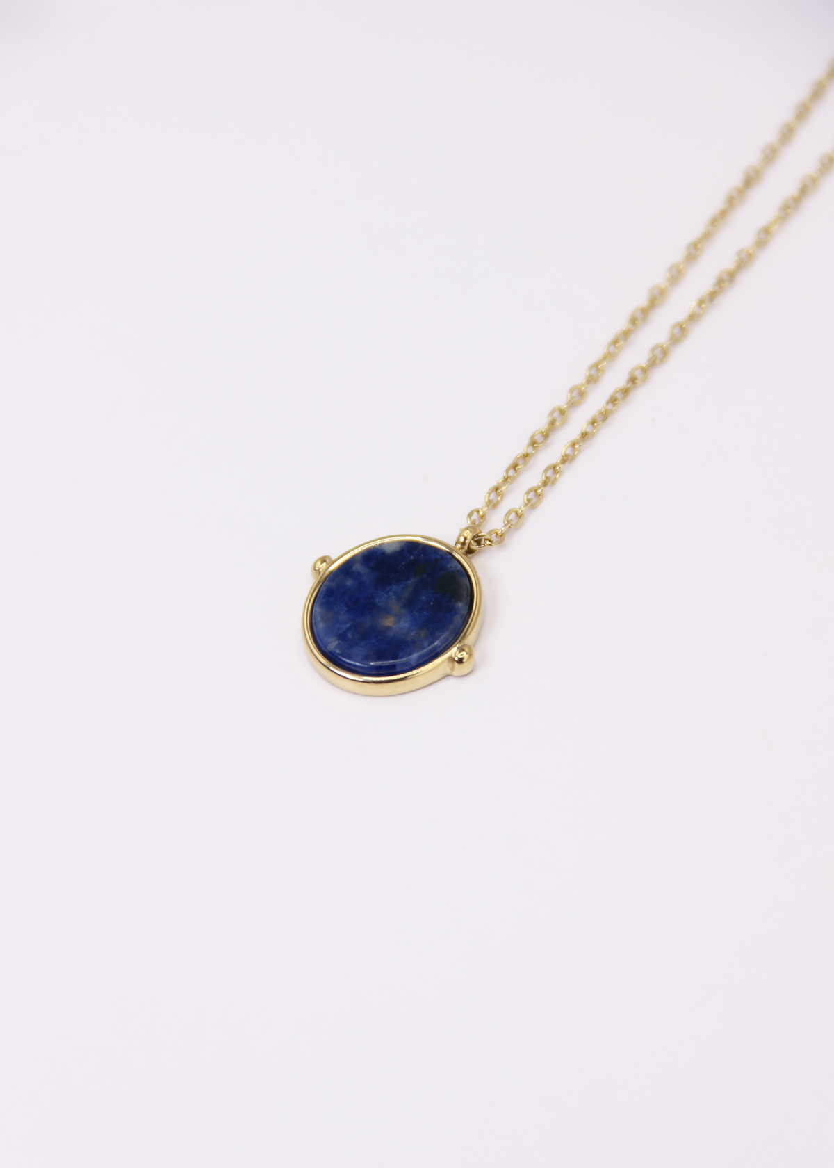 Collana in acciaio placcato oro con ciondolo ovale in pietra dura naturale e catena a maglia rettangolare fine. Disponibile in diversi colori, dal design elegante e senza tempo. Ogni pietra presenta variazioni naturali di colore e venature