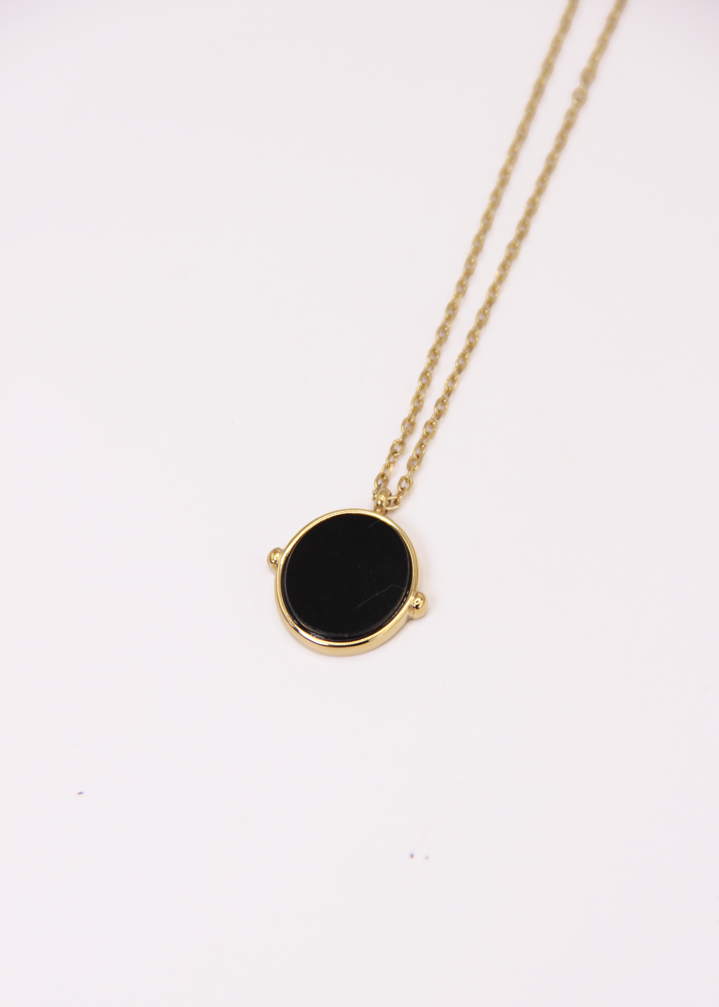 Collana in acciaio placcato oro con ciondolo ovale in pietra dura naturale e catena a maglia rettangolare fine. Disponibile in diversi colori, dal design elegante e senza tempo. Ogni pietra presenta variazioni naturali di colore e venature