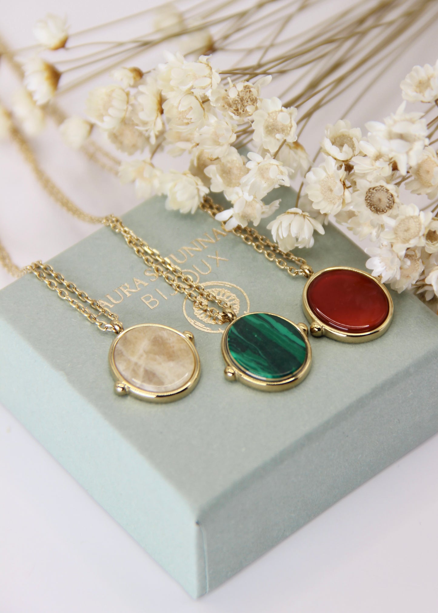 Collana in acciaio placcato oro con ciondolo ovale in pietra dura naturale e catena a maglia rettangolare fine. Disponibile in diversi colori, dal design elegante e senza tempo. Ogni pietra presenta variazioni naturali di colore e venature