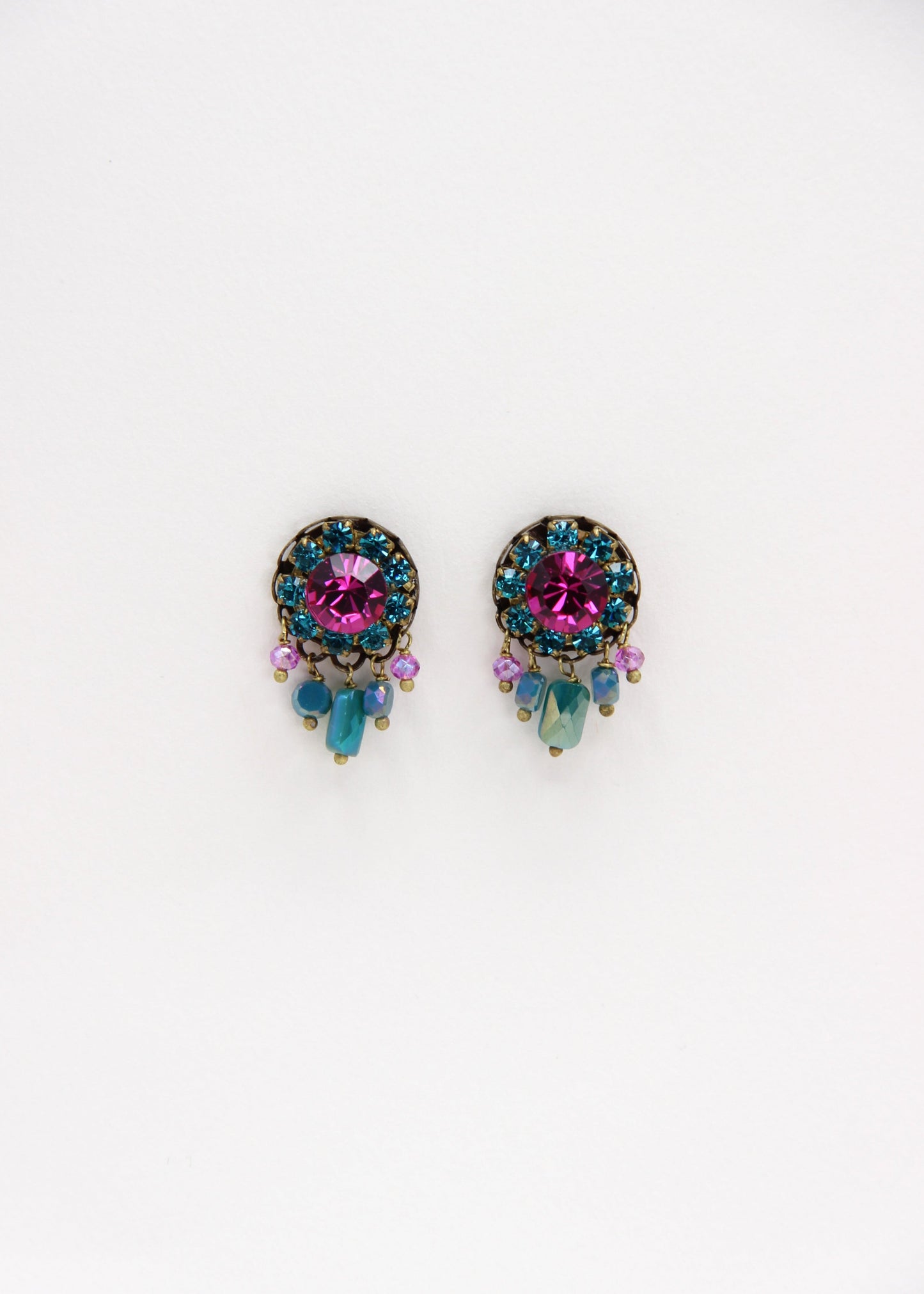 Orecchini artigianali Metropolitan Taormina fucsia e turchese, con cristallo centrale fucsia, corona di strass turchesi e cinque pietre sfaccettate iridescenti a cascata. Nickel free, stile mediterraneo per ogni occasione.