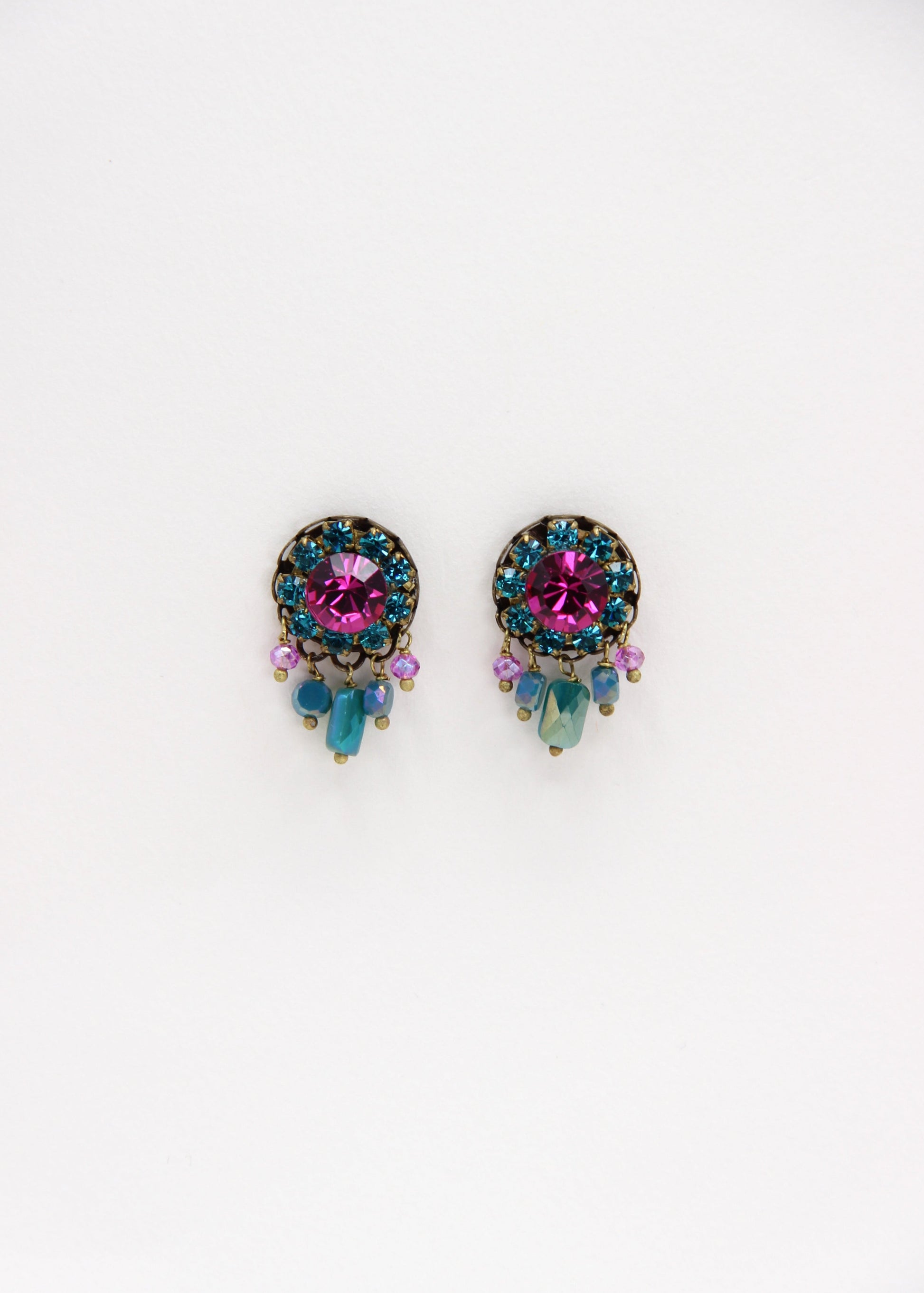 Orecchini artigianali Metropolitan Taormina fucsia e turchese, con cristallo centrale fucsia, corona di strass turchesi e cinque pietre sfaccettate iridescenti a cascata. Nickel free, stile mediterraneo per ogni occasione.